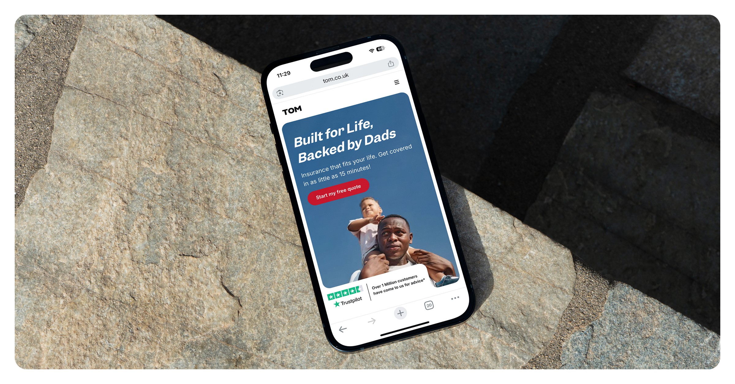 TOM website on phone — stone surface